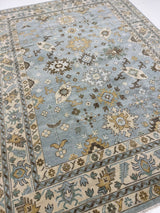 Katherine hand-knotted wool modern Oushak rug in light blue with cream, tan, ochre, and green