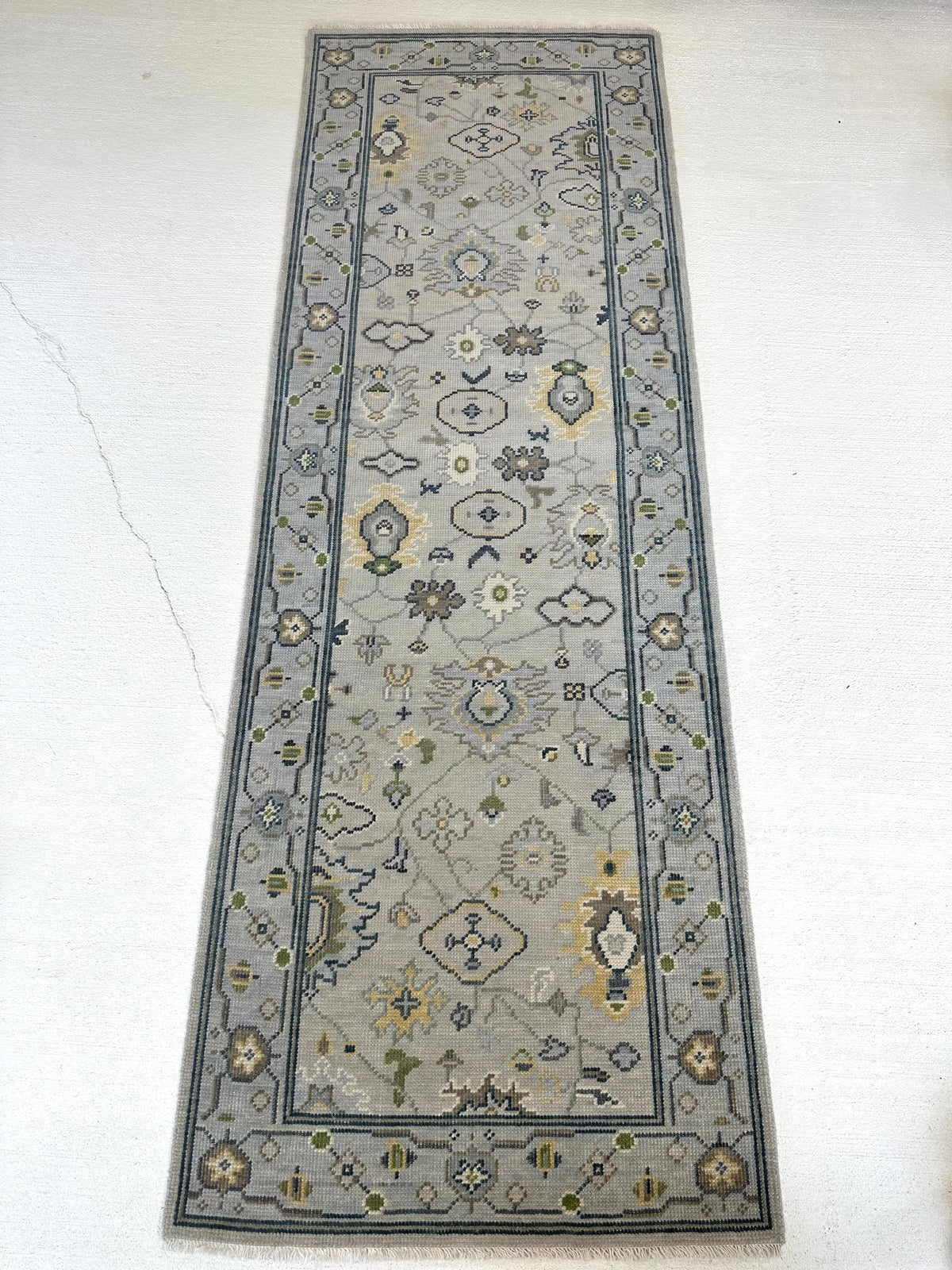 Margot modern Oushak rug with a gray center, light blue border, and mustard, green, cream, and navy accents, hand-knotted wool