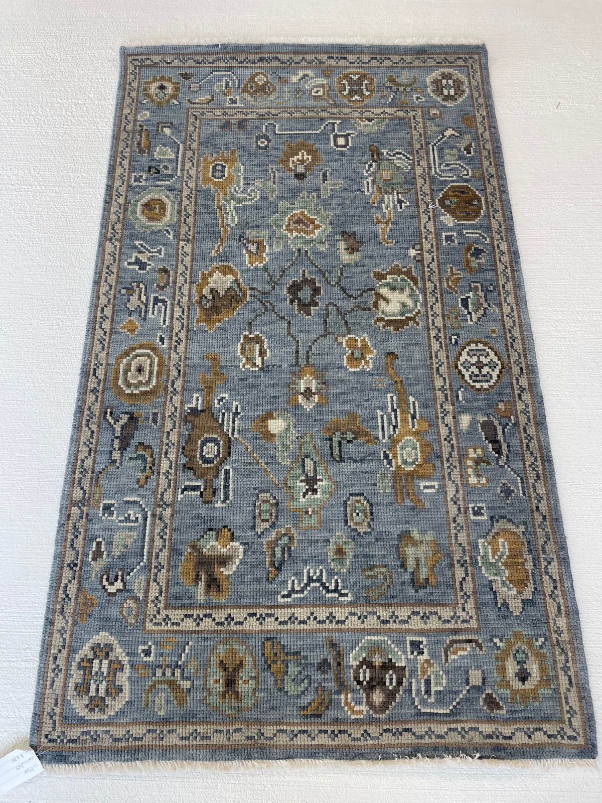 Mae modern Oushak rug, hand-knotted wool with a blue-gray foundation and cream, mustard, sage, and brown accents
