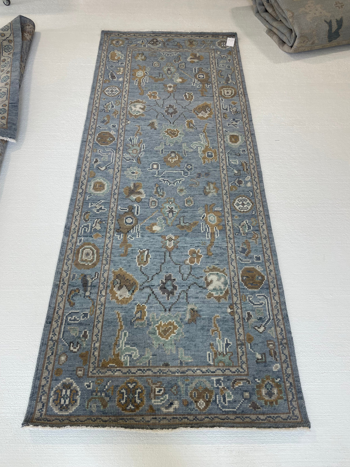Mae modern Oushak rug, a blue-gray foundation and cream, mustard, sage, and brown accents