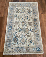 Ollie modern Oushak rug, cool gray foundation with taupe, cobalt blue, cream, and brown accents